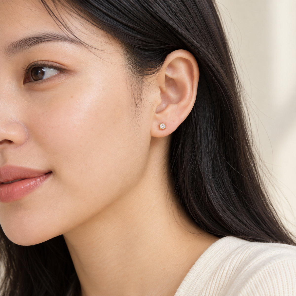 Gold-tone 3 mm stone stud earrings, worn on an adult model